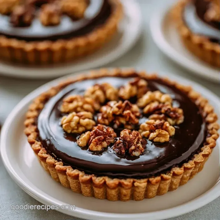 A wedge of dense chocolate tart on a ceramic plate, topped with a swirl of cream and a sprig of fresh green mint.