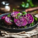 Roasted purple sweet potatoes on a rustic plate, garnished with fresh herbs and sesame seeds, with steam rising and a warm wooden table background.